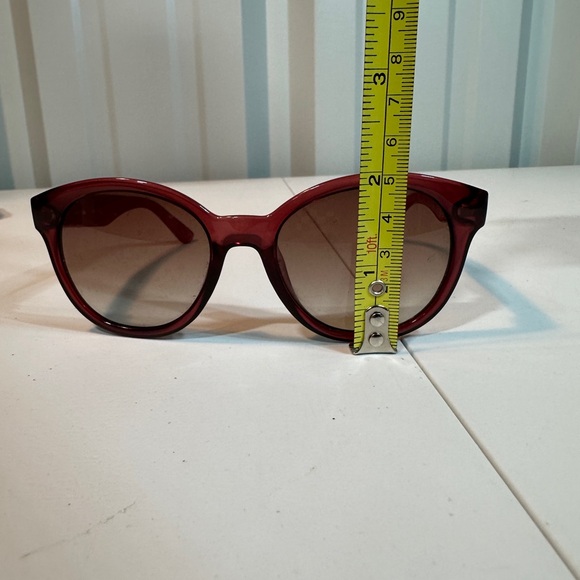 Pink women’s Lacoste sunglasses with pink striped carrying pouch
